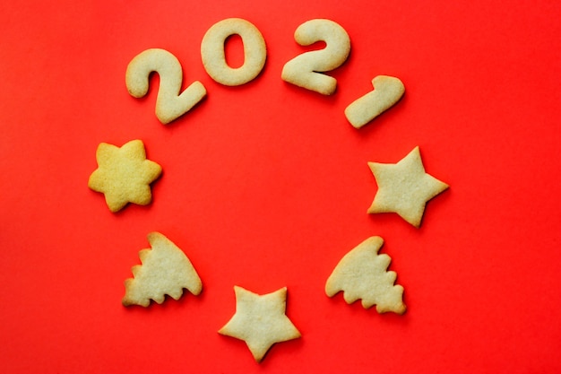 Concetto per il 2021. biglietto di auguri di natale fatto di biscotti su uno sfondo rosso. biscotti a forma di cerchio. la vista dall'alto, posto per il testo