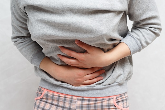 concept-abdominal pain. on a neutral wall