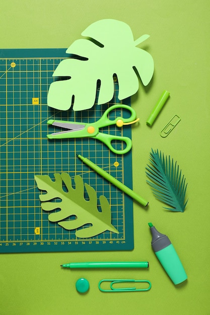 Concept of accessories for patchwork on a green background mat cutting