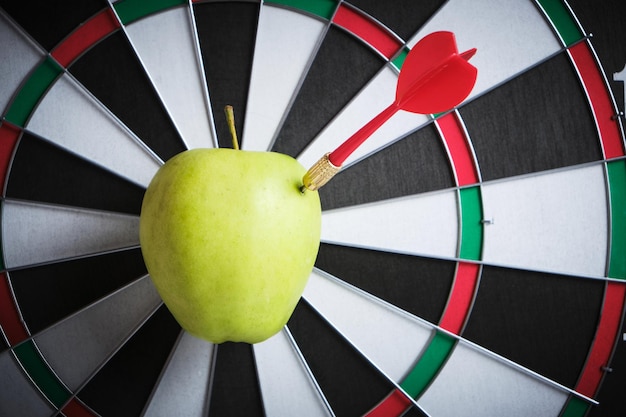 Photo concept achieving goal.achieving goals in business and life.dartboard with dart stuck right bullseye.