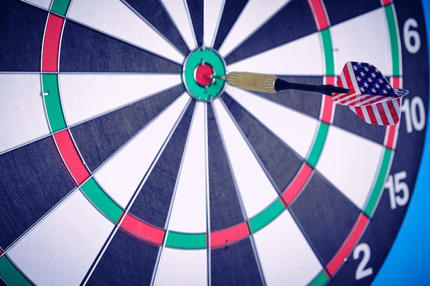 Concept achieving goal .achieving goals in business and\
life.dartboard with dart stuck right in center of target.