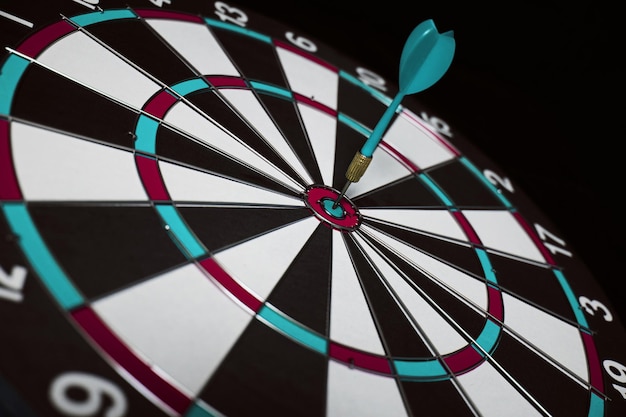 Concept achieving goal .achieving goals in business and
life.dartboard with darts stuck right in center of target.