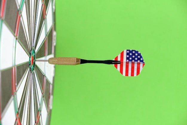 Concept achieving goal.achieving goals in business, politics
and life.dartboard with darts painted with american flag stuck
right into target.on green background.