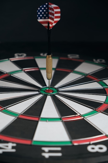 Concept achieving goal.Achieving goals in business, politics and life.Dartboard with darts painted with American flag stuck right into target.