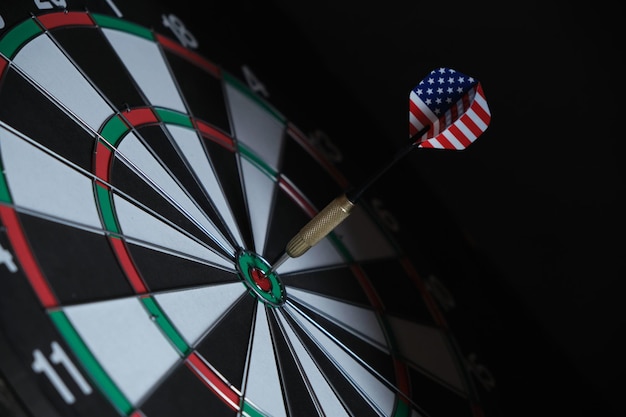 Concept achieving goal.achieving goals in business, politics
and life.dartboard with darts painted with american flag stuck
right into target.