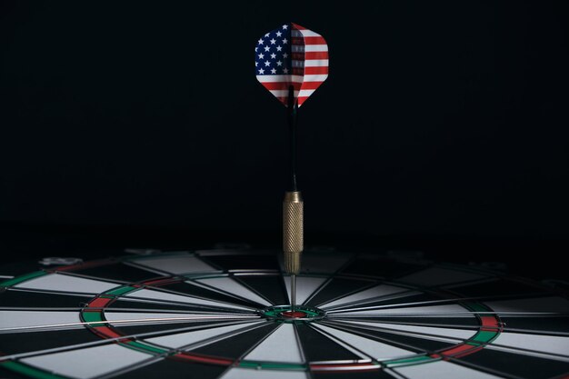 Concept achieving goal.Achieving goals in business, politics and life.Dartboard with darts painted with American flag stuck right into target.