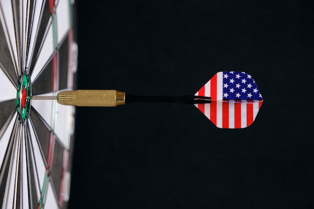 Concept achieving goal.Achieving goals in business, politics and life.Dartboard with darts painted with American flag stuck right into target.