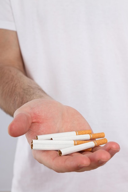 Foto concetto di dipendenza dal fumo di sigarette nelle mani di un uomo