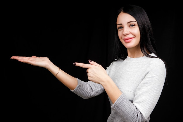 The concept of advertising. Positive, pretty, caucasion woman with a beaming smile