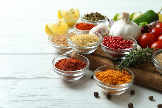 Concept of aromatic spices on white wooden table