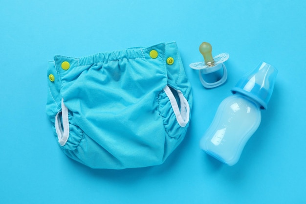 Photo concept of baby clothes with reusable diapers on blue background