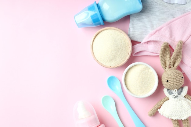 Photo concept of baby food with ñowdered milk on pink background