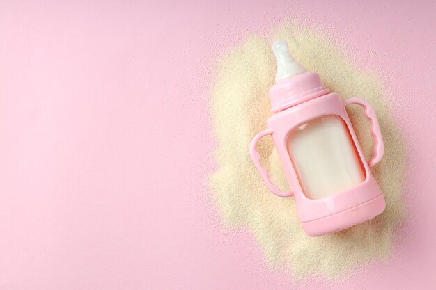 Photo concept of baby food with ãâowdered milk on pink background