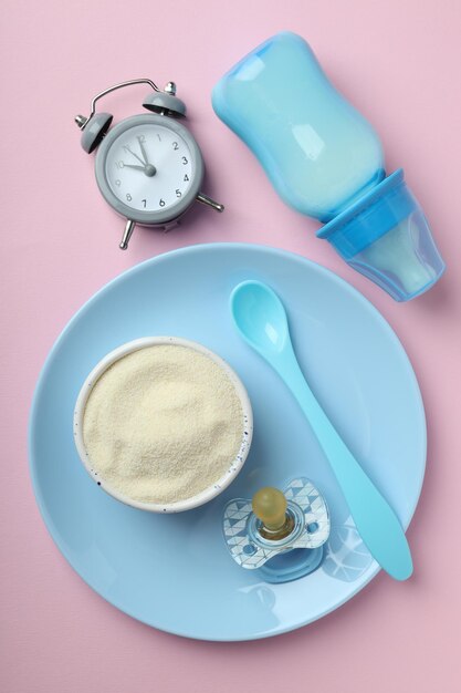 Concept of baby food with ÃÂowdered milk on pink background