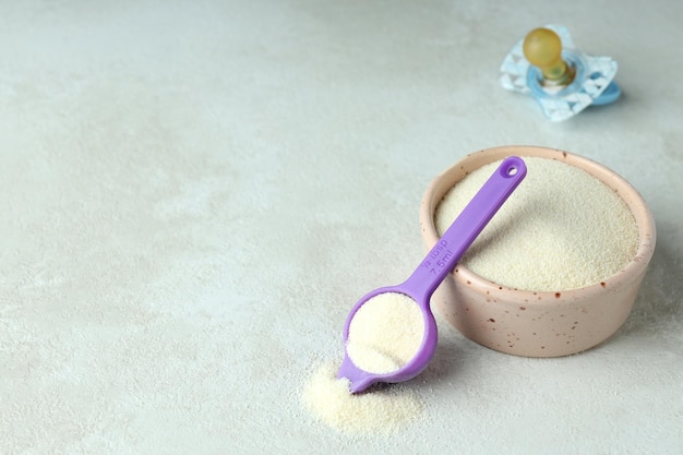 Concept of baby food with ÃÂowdered milk on white textured background