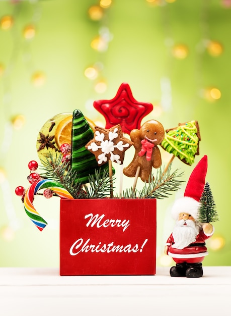 Концепция фон новый год 2022. Рождественские пряники и конфеты на палочках и Санта-Клаус. С Рождеством Христовым праздничная открытка.
