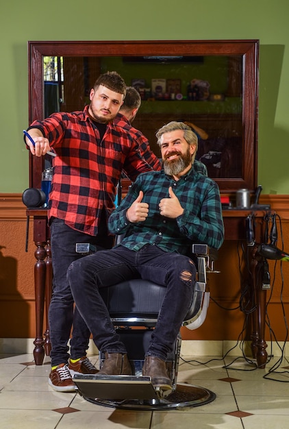 Concept Barbershop Jonge hipster man met baard die zijn haar knipt in een kapperszaak Professioneel kappers werk Lifestyle meester kapper doet het kapsel en styling met droger