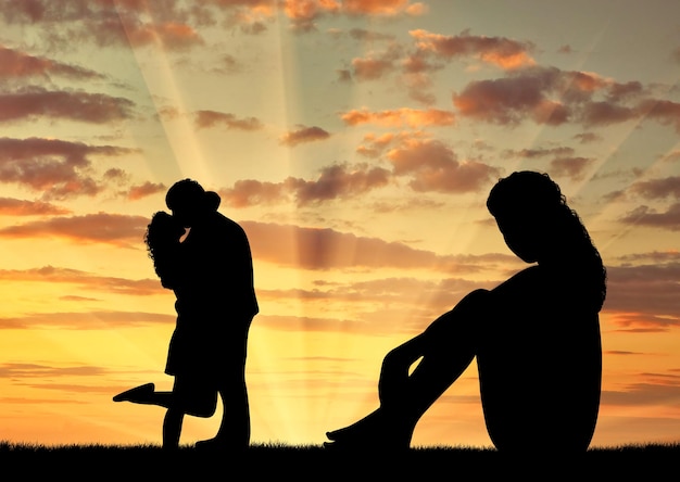 Concept of betrayal and treason. Silhouette of a lonely woman looking at loving couple at sunset