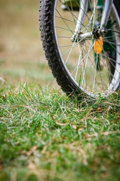 公園旅行の芝生の上のコンセプトバイクホイール