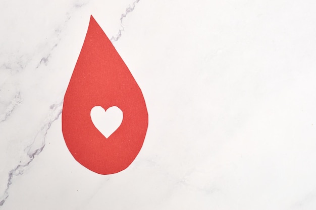 Concept of blood donation Red paper drop icon inviting to donate