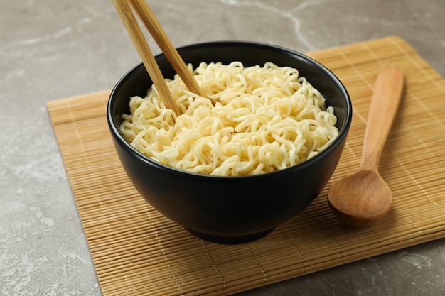 Concept of breakfast with bowl of noodles on gray background