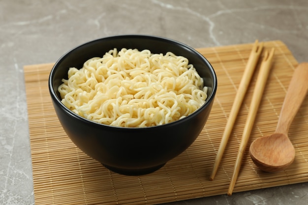 Concept of breakfast with bowl of noodles on gray