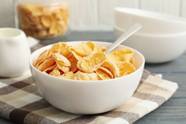 Concept of breakfast with cornflakes on wooden table