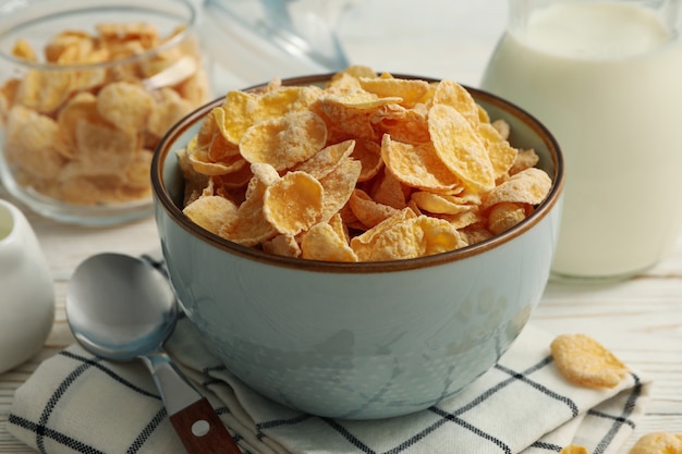 Concept of breakfast with muesli and milk on white wooden table