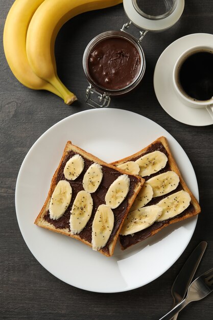 Concetto di colazione con pane tostato con banana su fondo in legno