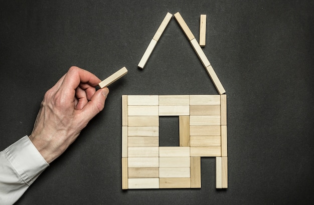 Foto il concetto di costruire una casa sotto forma di blocchi di legno.