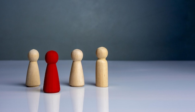 Foto concept business e hr per la leadership e il team leader di una bambola di legno spiccano di fronte.