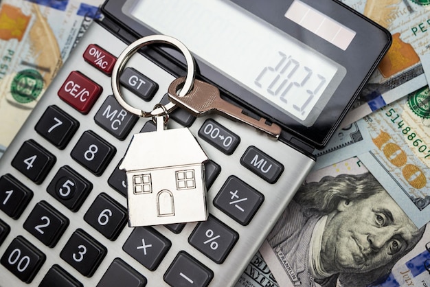 The concept of buying renting lending real estate The keychain and the key to the house lie on the calculator and money