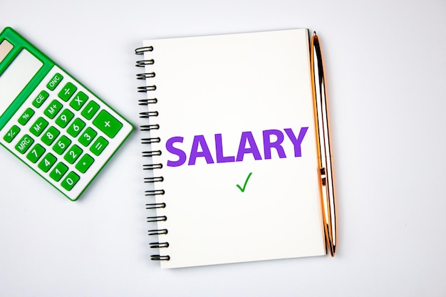 The concept of calculation payroll for an employee The word SALARY on a notepad next to a calculator