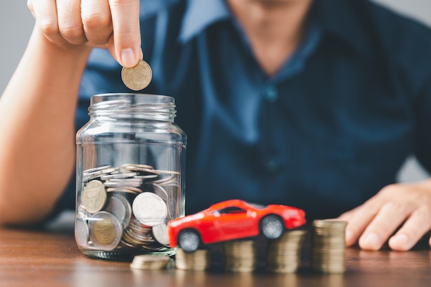 자동차 보험 사업의 개념은 세금과 새 차에 대한 대출로 판매를 구매합니다. 배경에 스택 동전 돈이 있는 자동차 장난감 차량 자동차에 대한 운송 금융 비용 대출 관리 계획