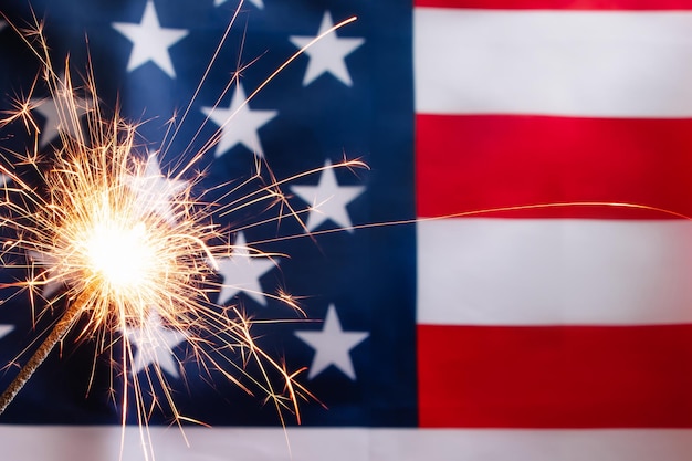 Concept for celebrating US Independence or Memorial Day Sparkler on a background of American flag