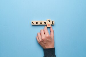 Photo the concept of change and chance. hand picks up letters on a yellow background.