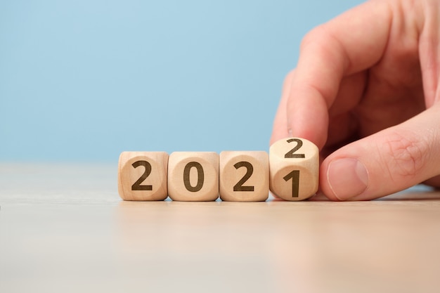 Concetto di cambiare l'anno dal 2021 al 2022 su cubi di legno a mano.