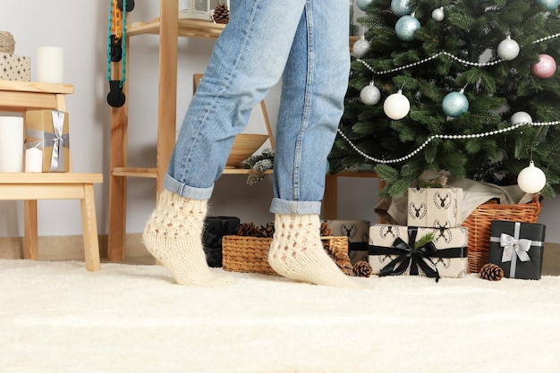 Concept of Christmas and Happy New Year female legs and Christmas interior