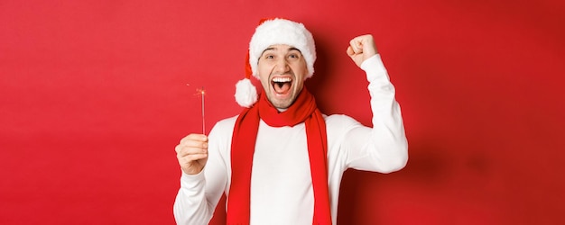 Concept of christmas winter holidays and celebration portrait of excited handsome man raising hand u