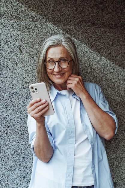 Concept of communication in old age mature senior woman using mobile phone for texting and internet messengers Womans active engagement with technology and desire to stay connected in digital age