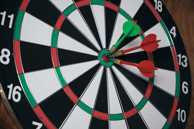 Concept of competition and goal achievementAchieving goals in business and lifeDartboard with three darts stuck right center of target