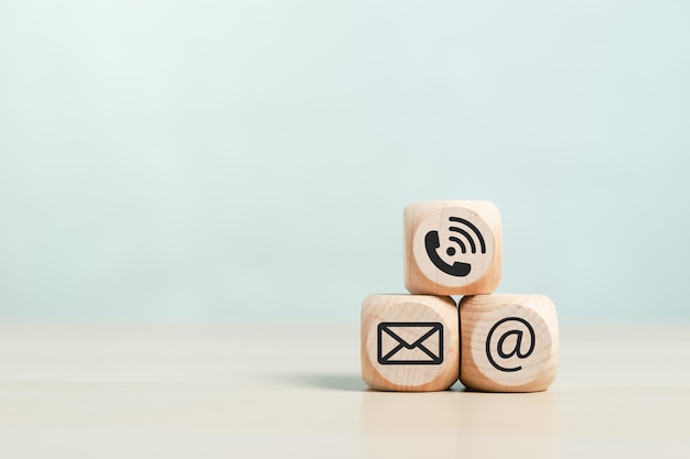 Concept of contact us blank wooden cubes square dice with symbol email telephone address placed on wood background