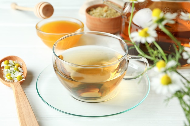 Concept of cooking chamomile tea on white wooden table