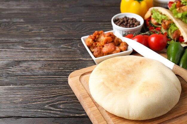 Concept of cooking pita on wooden background