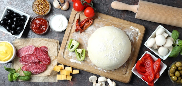 Concetto di cottura della pizza su sfondo scuro con texture