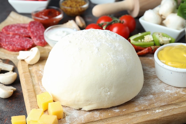 Concetto di cottura della pizza su sfondo scuro con texture