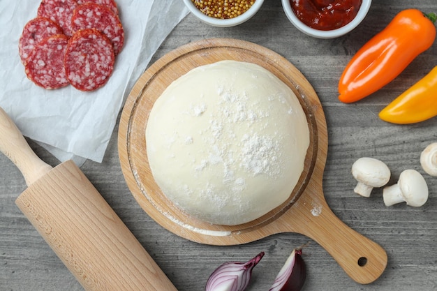 Concept of cooking pizza on gray wooden background