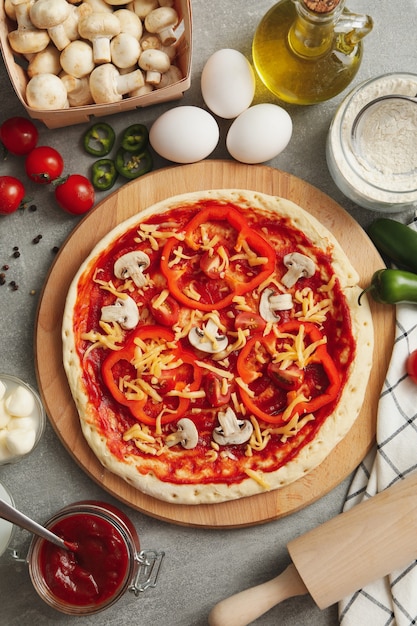 Concetto per cucinare la pizza con ingredienti sul tavolo grigio