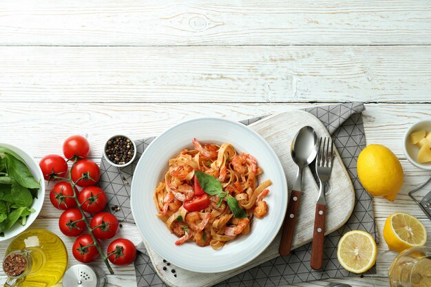 Concept of cooking shrimp pasta on white wooden table