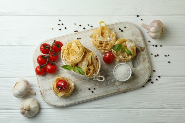 Concept of cooking tasty pasta on white wooden table